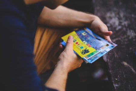Hands holding a stack of colorful printed mailers