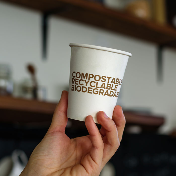 man holds biodegradable paper cup