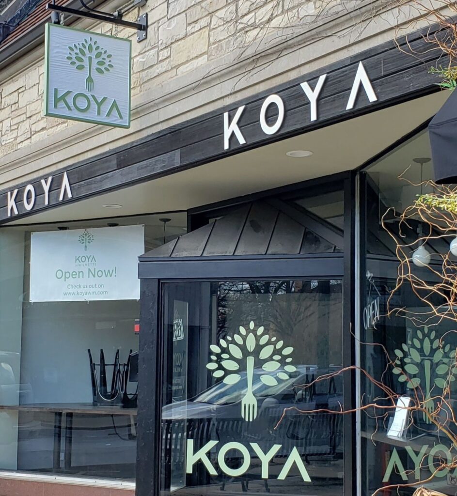 KOYA storefront with blade sign, white channel letters, and custom window graphics for walk-up visibility and branded street presence
